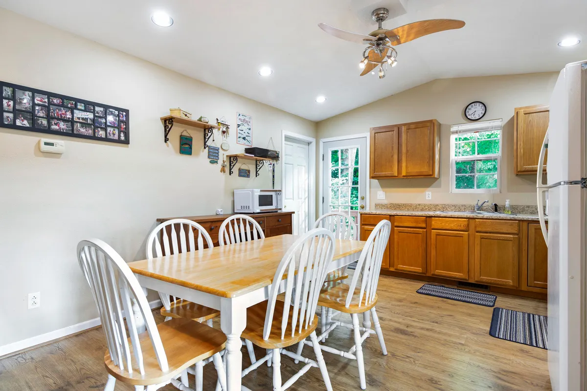 This image features a warm, welcoming dining area complete with a dining table, kitchen cabinets, wall decor, and windows letting in natural light. The scene is set up for both family meals and entertaining, perfectly aligning with group gatherings, game nights, and shared experiences described in the section.